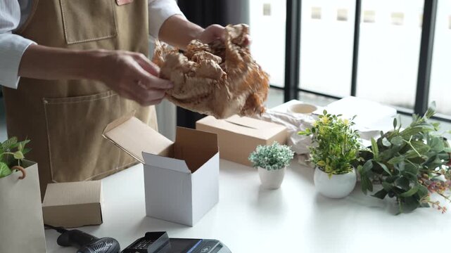 Asian business owner packaging with eco bubble wrap