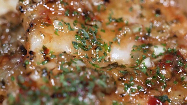 A mouth-watering, high-definition close-up shot of tender cod fillets seared to a golden brown in a rich garlic butter sauce. The fish is lacquered with a vibrant, glossy sweet chili and lime glaze an
