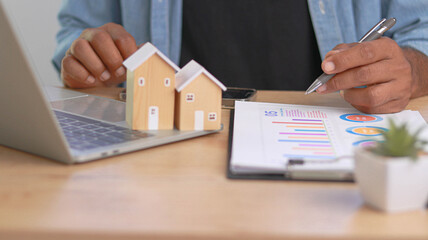 Real estate investment and property market analysis concept with house models, financial charts and...