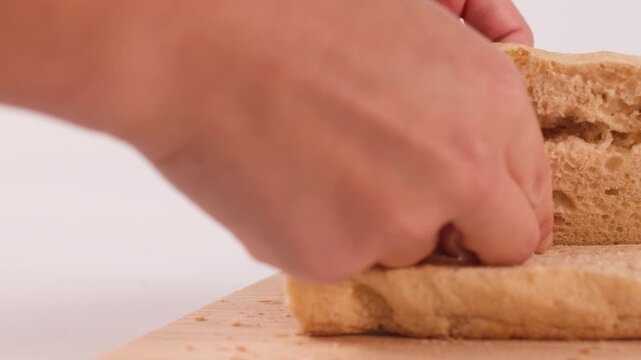 Hands Tearing Fresh Crusty Focaccia Bread on Wooden Board