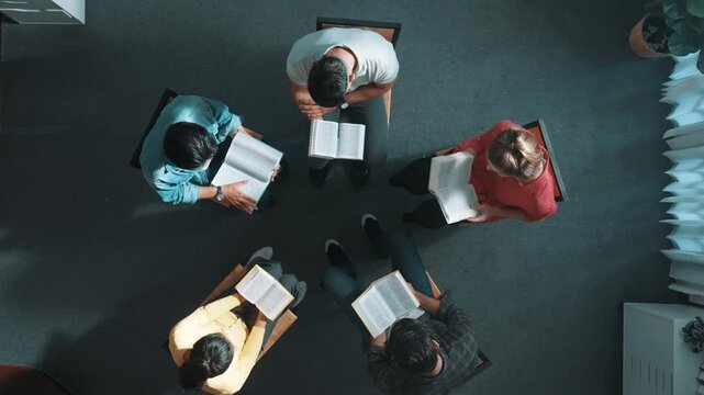 Time lapse of prayers reading at bible books and sitting in circle with bible book on laps. Aerial view of diverse people looking at book while studying with faith, trust and hope, calm. Symposium.