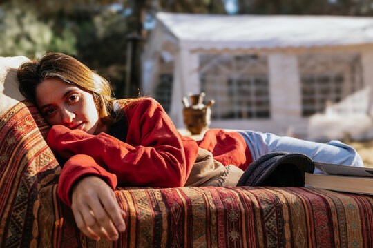 Woman relaxing outdoors lying on patterned couch