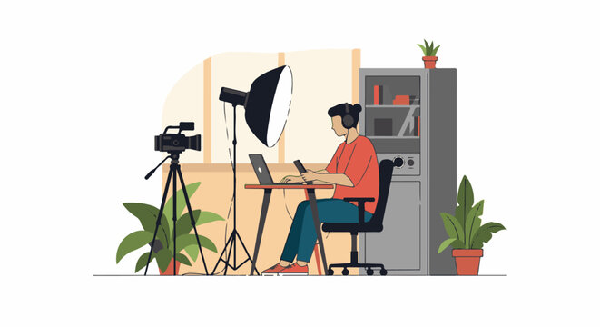 A person sits at a desk with a camera, laptop, and softbox light