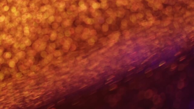 Sparkle glitter reflection. Hypnotic glow. Defocused color light transition rotate optic lens. Mystic bokeh orange rays abstract background.