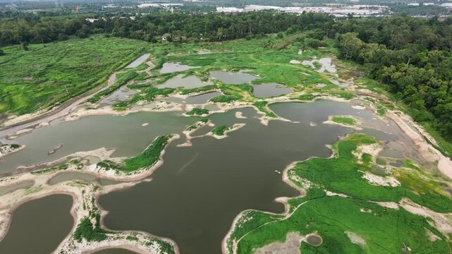 Aerial drone footage of a calm lake reflecting clouds and mountains at sunset light. Ideal for nature, travel, environment, wetland, and cinematic landscape projects.