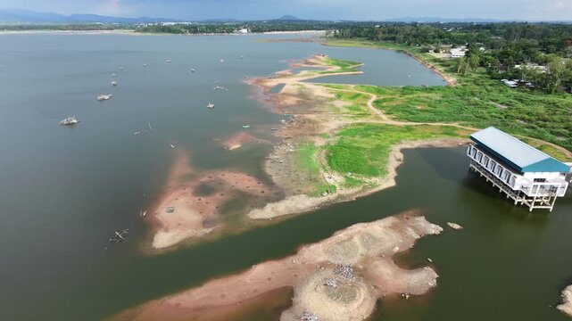 Aerial drone footage of a calm lake reflecting clouds and mountains at sunset light. Ideal for nature, travel, environment, wetland, and cinematic landscape projects.