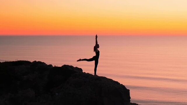Yoga silhouette on cliff at sunset