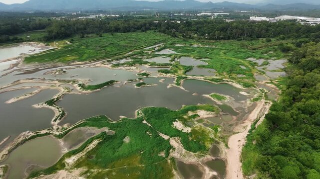 Aerial drone footage of a calm lake reflecting clouds and mountains at sunset light. Ideal for nature, travel, environment, wetland, and cinematic landscape projects.