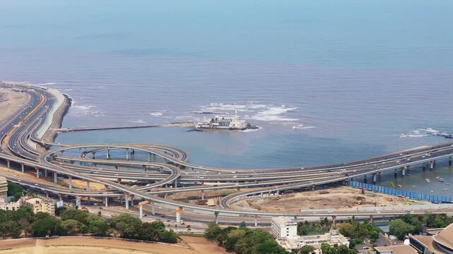 Elevated panoramic view of the intricate worli sea link highway interchange in mumbai, india, showing daily traffic flow against the arabian sea with the haji ali dargah mosque nearby
