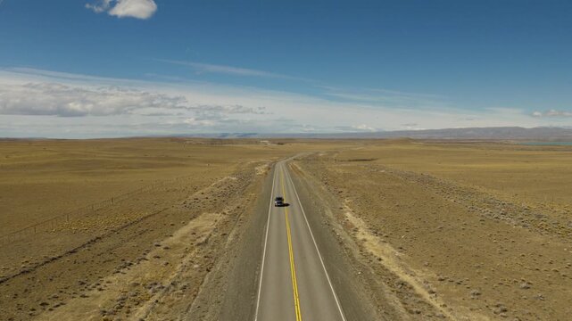Pickup truck travels along Ruta Nacional 40 across the arid Patagonian steppe near El Chalt&eacute;n, Santa Cruz, Argentina, open rangelands and expansive Southern Patagonian landscapes, drone tracking shot.