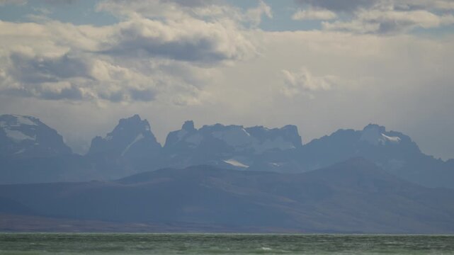 Fitz Roy Massif towers above Lago Viedma near El Chalt&eacute;n, Santa Cruz, Argentina, with snow-covered granite peaks and changing cloud formations captured in timelapse.