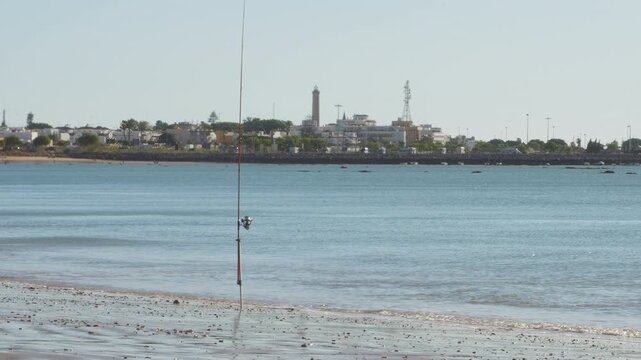 Fishing pole at the beach with Chipiona town on the background, Cadiz, Spain