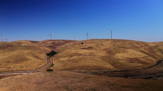Drone view over wind turbines at the Altamont Pass Wind Farm near Dublin, California. Applicable to clean energy, environmental, and industrial aerial projects