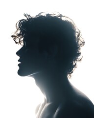 Fototapeta premium Silhouette of a young man with curly hair in profile against a bright white background.