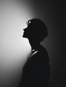 Silhouette of a woman looking upwards with hope and contemplation.