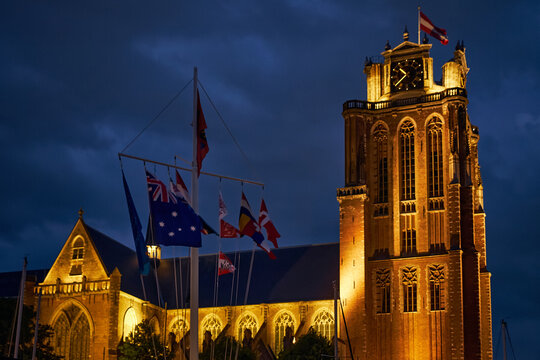 Dordrecht, Netherlands - 30 May 2026: View of the illuminated Grote Kerk at night, featuring its historic brick tower and gothic architecture with flags during the Dordt in Stoom.