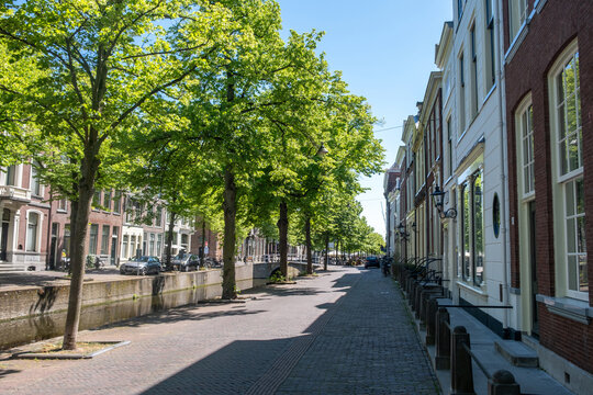 Historic canal houses and arched bridge in Delft City Centre on sunny spring day, Netherlands