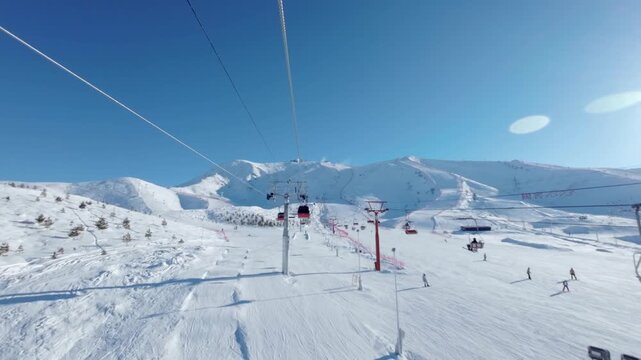 Chairlift Over Snowy Mountain Ski Resort on Sunny Winter Day