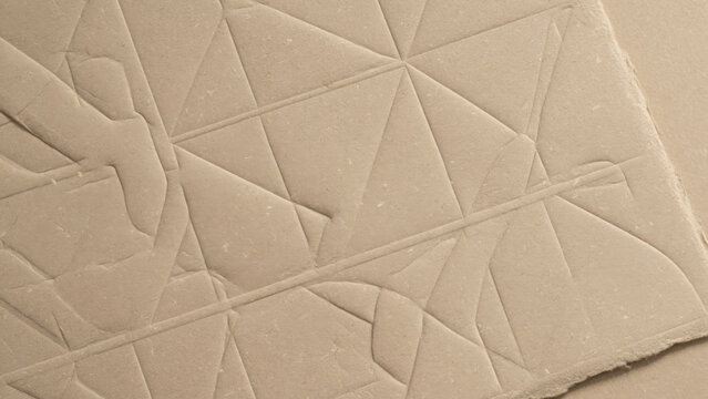Beige cardboard surface with embossed geometric triangle patterns and sharp generated using ai