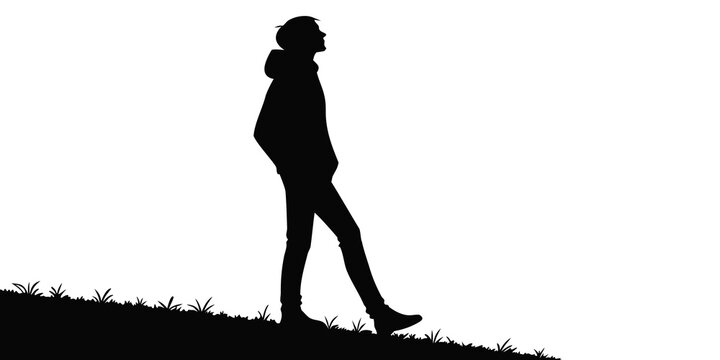 Silhouette of a man walking up a grassy hill with confidence and determination looking forward towards the summit and his future goals silhouette climbing progress determination confidence
