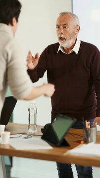 Elderly and young male colleague are arguing excitedly in office Elderly and young male colleague are arguing excitedly in office of company. Disagreements, insubordination, inconsistency of views 