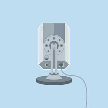 A modern digital security camera stands on a flat surface