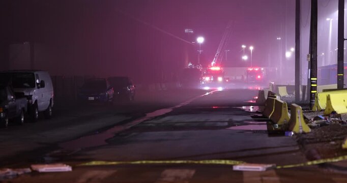 A Fire Engine with flashing red lights arrives at the scene of an emergency at night.