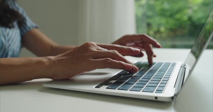 Close up. Hand of middle woman using laptop, working with computer at home office natural light	