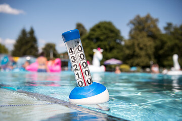 Fototapeta na wymiar Sommer: ein Poolthermometer in einem Freibad zeigt eine Wassertemperatur von 27 Grad Celsius an.