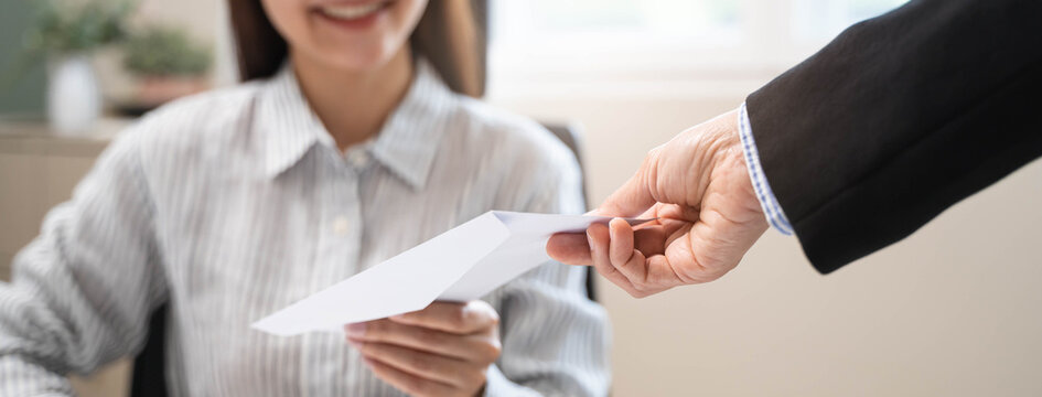 female employee smiling when she receive salary from boss.