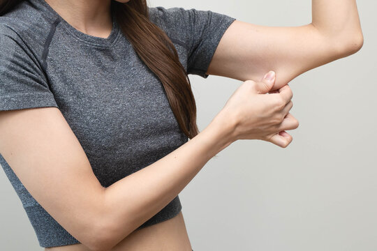 Woman pinching flabby arm fat, loose skin and weight loss concept