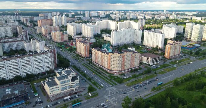 Aerial pull-back shot of a green residential district in Zelenograd under dark dramatic clouds with visible rain approaching in the distance