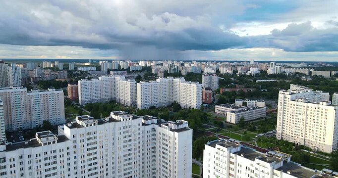 Aerial shot of a green residential district in Zelenograd under dark dramatic clouds with visible rain approaching in the distance