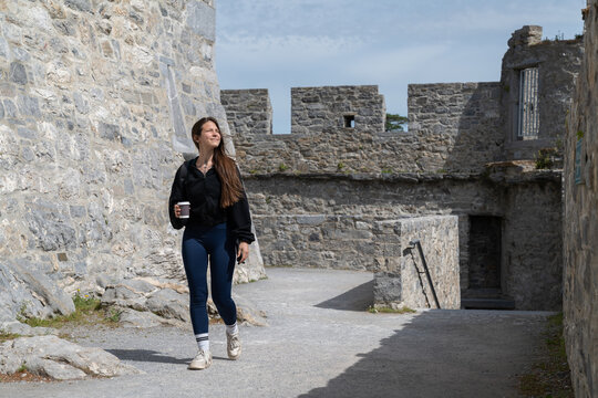 Woman walking through ancient castle walls exploring history