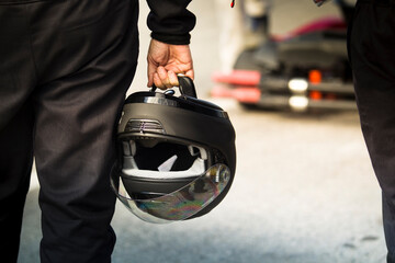 Naklejka premium Close up rear view of a person carrying a black helmet by the strap
