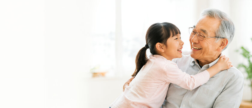 敬老の日に祖父へ抱きつく孫娘の家族写真