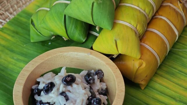 Thai dessert made of sticky rice, banana and coconut milk, all wrapped in banana leaves.