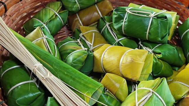 Thai dessert made of sticky rice, banana and coconut milk, all wrapped in banana leaves.