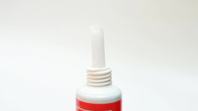 White cream coming out of a tube on white background, medical, cosmetic or skincare product