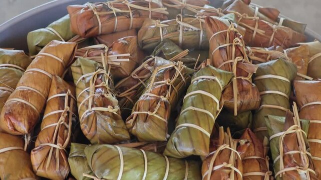 Thai dessert made of sticky rice, banana and coconut milk, all wrapped in banana leaves.