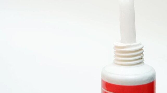 White cream coming out of a tube on white background, medical, cosmetic or skincare product