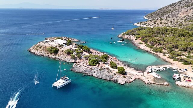Stunning 4K drone footage revealing the charming Aponisos island, a secluded and picturesque islet connected to Agistri, framed by vivid turquoise waters and rugged coastline in the Mediterranean Sea,