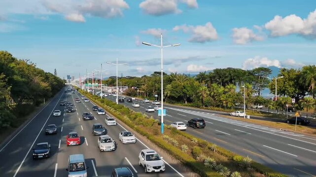 Heavy traffic on wide palm-lined urban boulevard under blue sky