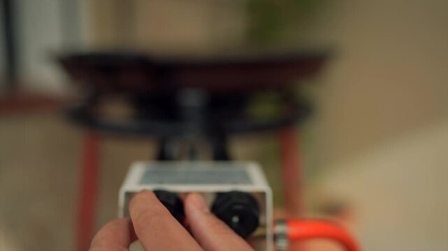 Person adjusting gas burner control knob