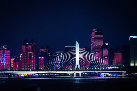 Guangzhou, Guangdong Province, China - 22 February 2024: View of the illuminated Liede Bridge spanning the Pearl River at night, set against the vibrant skyline.