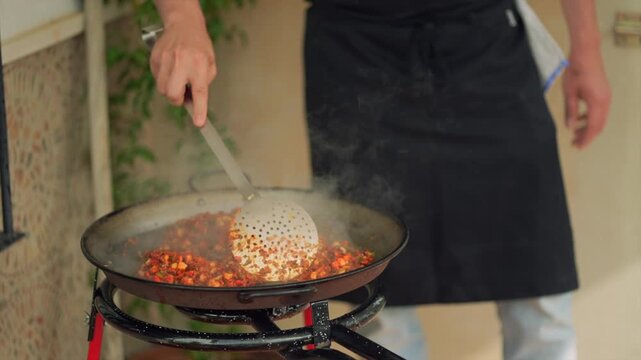 Chef cooking traditional spanish paella outdoors