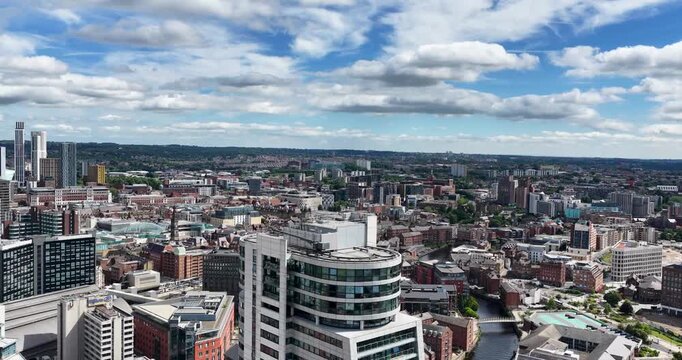 Aerial footage of the Leeds city centre featuring the Bridgewater Place apartment and modern office buildings historic warehouses and the city skyline beneath a bright summer sky with scattered clouds