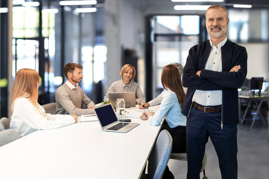 Portrait of businessman standing in the office with arms crossed and smiling looking at camera