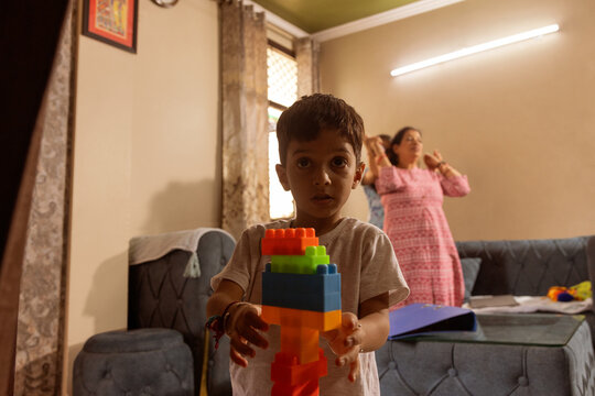 Boy playing with colorful blocks indoors
