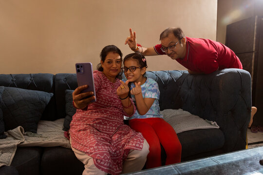 mother taking selfie with her daughter and husband 